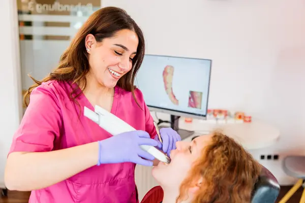 Zahnärztin scannt Patientin digital zur modernen Zahnabdrucknahme in der Zahnarztpraxis.